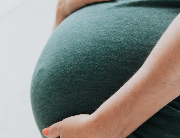 une femme enceinte se tient le ventre après un test ADN de paternité prénatal